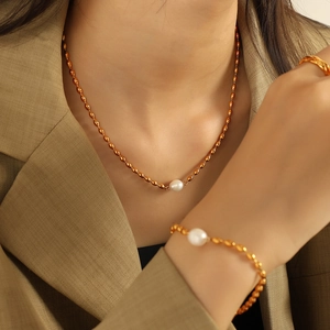 Elegant gold pearl necklace and bracelet set worn by model with modern urban style
