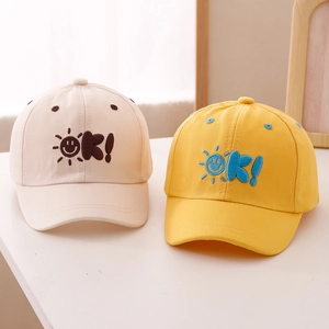 Kids baseball caps with sun embroidery and OK letters in cream and bright yellow colors