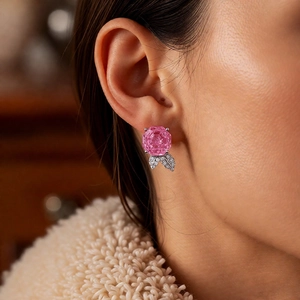 Detailed close-up of pink flower earrings with zircon leaves worn on a model's ear