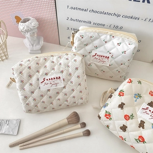 Lot de trois trousses à maquillage matelassées aux motifs de fleurs et de cerises