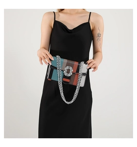 Detail of colorful striped crossbody bag with large rhinestone buckle and silver chain