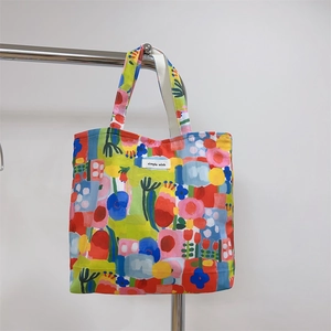 Close-up of a floral canvas tote bag with artistic prints and simple wish woven label
