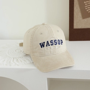 Détail de la casquette beige en coton avec broderie WASSOP bleue et texture sergé