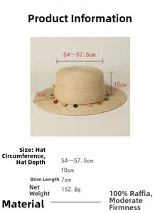 Detail of 100% natural raffia straw hat with colorful floral trim and flat brim design