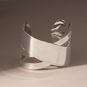 Vue détaillée du bracelet jonc argenté à couches géométriques irrégulières au fini miroir