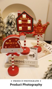 Detail of wooden LED Santa Stop Here signs with warm glowing lights and festive decor