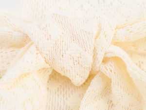 Détail macro de dentelle crème élégante avec texture tricotée complexe et design noué doux