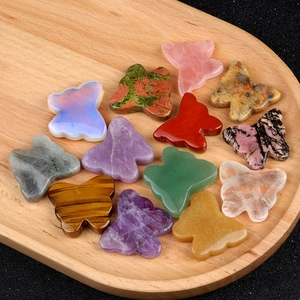 Various natural crystal butterfly stones displayed on a wooden tray for home decor