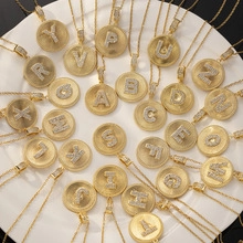 Vertical view of twenty-six gold plated round letter pendants with zircon stones