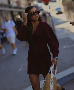Détail d'un ensemble en maille bordeaux foncé avec col en V et manches longues élégant