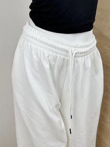 Detailed shot of elastic waistband with white drawstring on heavy cotton sweatpants
