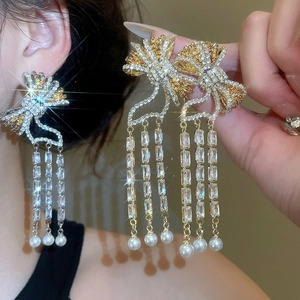 Detailed view of luxury bow earrings with zircon tassels and hanging pearls for women