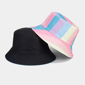 Detail of reversible bucket hat in black and colorful vertical rainbow stripes texture