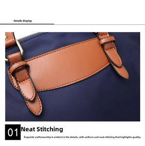 Macro shot showing white stitching on brown leather handles of the navy oxford handbag