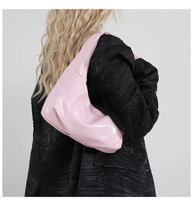 Nahaufnahme der rosa glänzenden Hobo-Tasche aus Ölwachsleder mit Nieten und Schleife