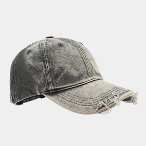 Detail showing distressed holes and washed denim texture on a grey baseball cap