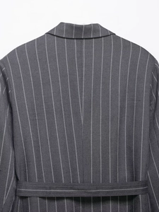 Detail of grey pinstripe blazer back showing professional stitching and waist belt