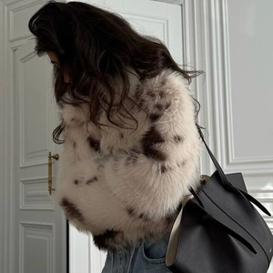 Fashionable faux fur coat with animal print pattern, styled with a tote bag and jeans