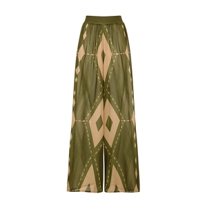 Detail of high-waisted wide-leg beach pants in olive green with beige geometric prints