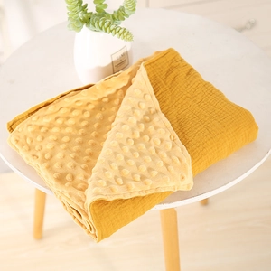 Double-sided ginger baby blanket featuring soft minky dots and breathable muslin fabric