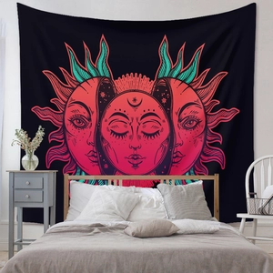 Detail view of a bohemian tapestry with sun and moon motifs hanging above a bed