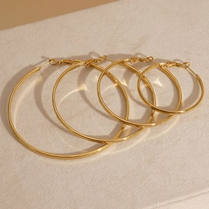 Set of four gold minimalist stainless steel hoop earrings in various graduated sizes