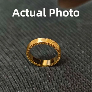Detail of 18K gold titanium steel ring featuring numerical engravings on a textured band