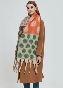 Dettaglio della sciarpa a pois multicolore con spesse nappe e morbida trama a maglia