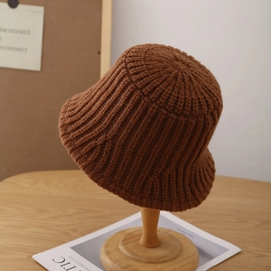 Detailed vertical knit texture of a brown winter fisherman hat with thick woolen material