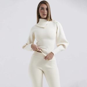 Detail of off-white knit set with asymmetric neck buttons and lantern sleeves