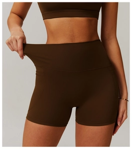 Detail showing the elastic fabric and side pocket of high waist brown yoga shorts
