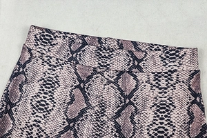 Close-up of high-waist snake print pants showing the elastic fabric and detailed texture
