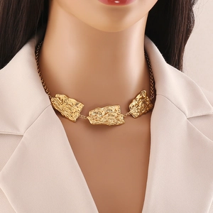 Minimalist gold irregular textured geometric pendant necklace worn by a fashion model