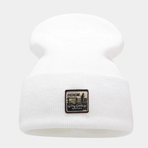 Detail of white ribbed knit beanie featuring vintage denim supplies woven label