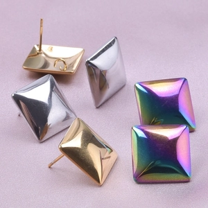 Detail of square geometric stud earrings in gold, silver, and iridescent finishes