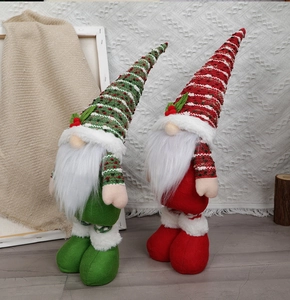 Detailaufnahme von gestrickten Weihnachtswichteln in Rot und Grün mit Plüschbärten