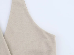 Dettaglio del tessuto a maglia beige che mostra la trama fine e cuciture senza cuciture