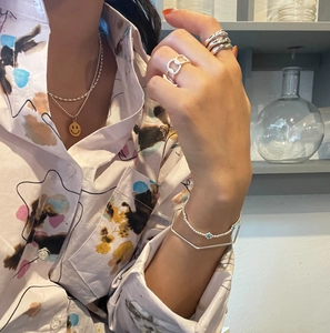 Detail of layered S925 sterling silver rings and jewelry on a stylish female model