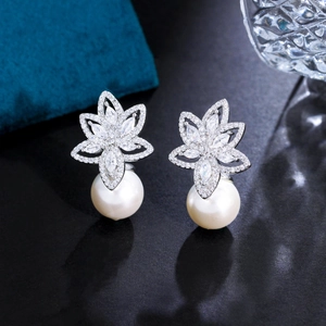 Elegant floral pearl earrings with marquise-cut zircon stones on a blue velvet box