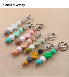 Close-up of colorful cactus silicone beaded keychains with metal rings on beige background