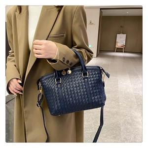 Détails du tissage en cuir bleu marine et des ferrures dorées du sac à main