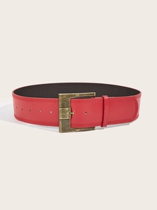 Detail of vintage red wide waist belt with antiqued bronze rectangular metal buckle