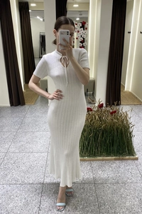 Dettaglio del vestito lungo in maglia bianca con trama a costine e scollatura cut-out