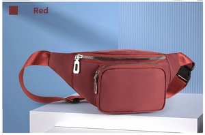 Close-up of waterproof red nylon waist bag with silver zippers on a display stand