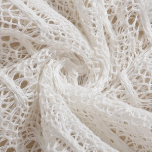 Macro detail of breathable white mesh lace fabric with intricate hollow woven texture