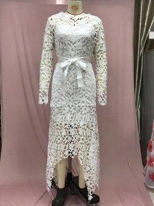 Close-up of white floral lace fabric and satin bow belt on an irregular hem midi dress