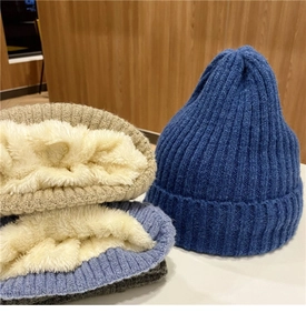 Dettaglio del caldo berretto invernale in maglia con spessa fodera in pile bianco