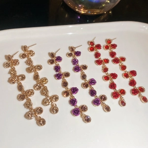 Detail of floral tassel dangle earrings in champagne, purple and red vintage styles