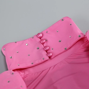 Detail of pink turtleneck dress showing sparkling rhinestones and four round buttons