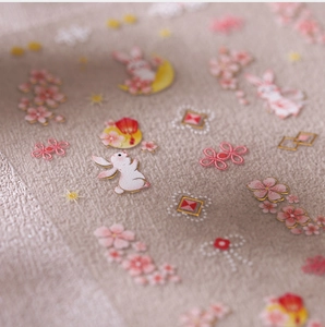 Macro shot of 3D gold-stamped nail stickers with cherry blossoms and white rabbits